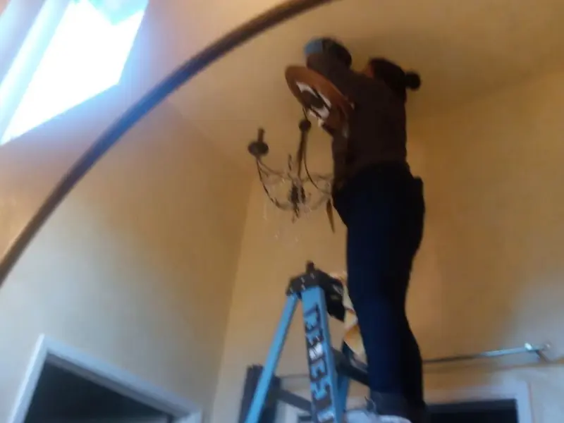 Electrician installing a chandelier in a South Union residence